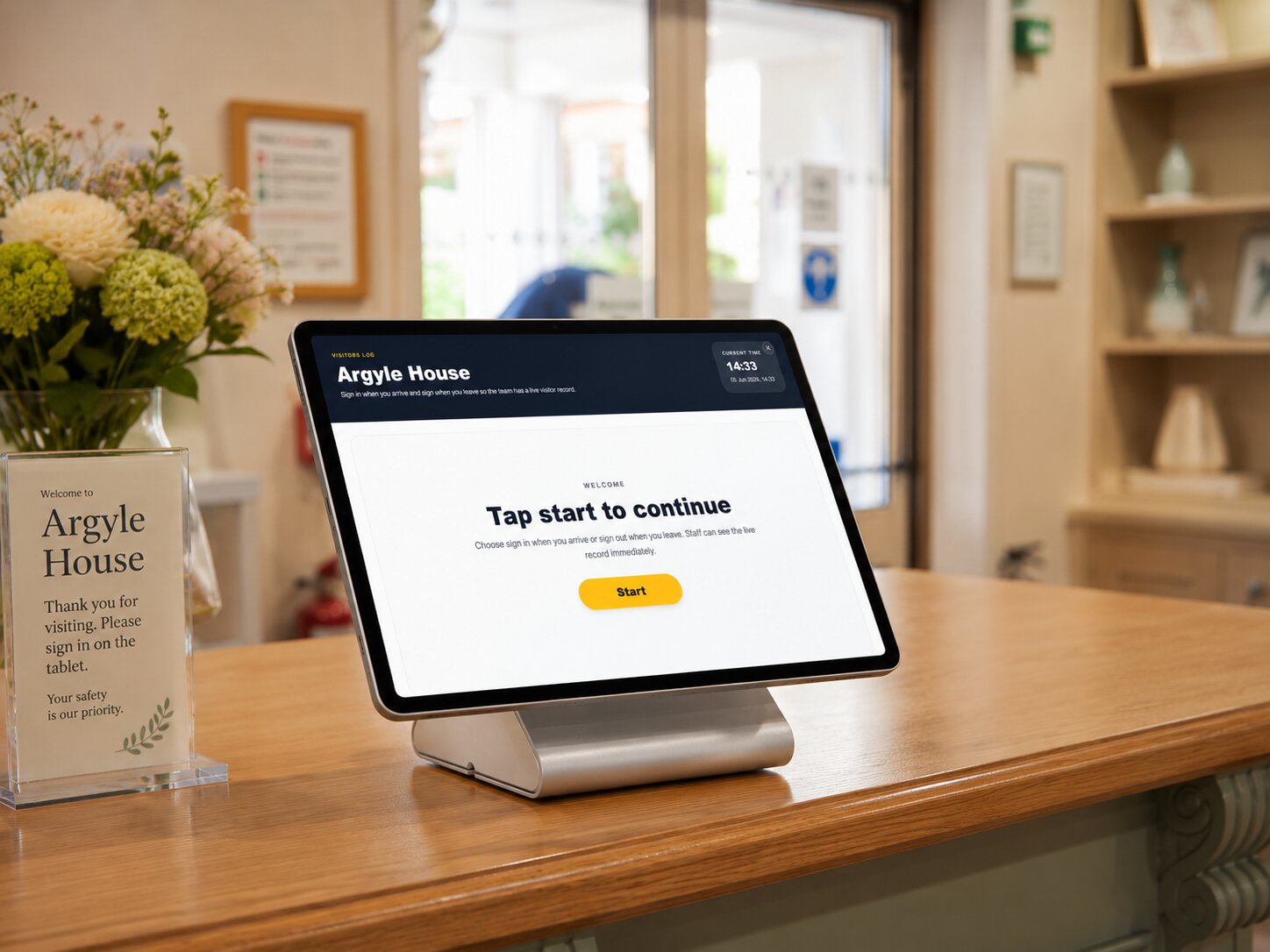 Care home visitors sign in log shown on a reception tablet and stand.